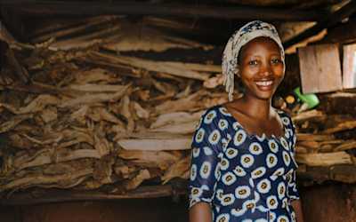 A woman standing in front of a pile of wood