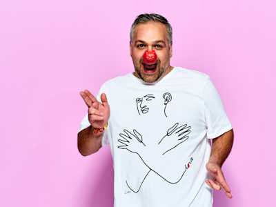 Smiling man wearing red nose and Red Nose Day t-shirt