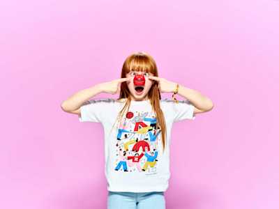 Child comedically pointing at red nose on their face