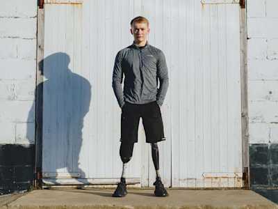 Billy standing against a white wall and facing the camera.