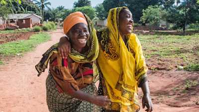 two women laughing on a road