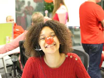 Call centre volunteer smiling wearing a Red Nose