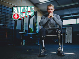 Billy Monger sitting down and smiling at the camera.