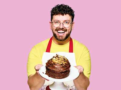 Adult smiling and holding chocolate cake