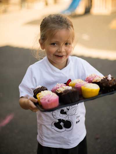 Girl with tray of cupcakes