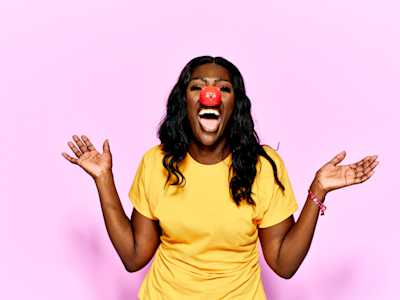 Person laughing and wearing red nose