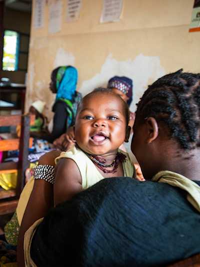 Baby smiling in a malaria clinic