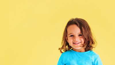 A young child smiles at the camera.