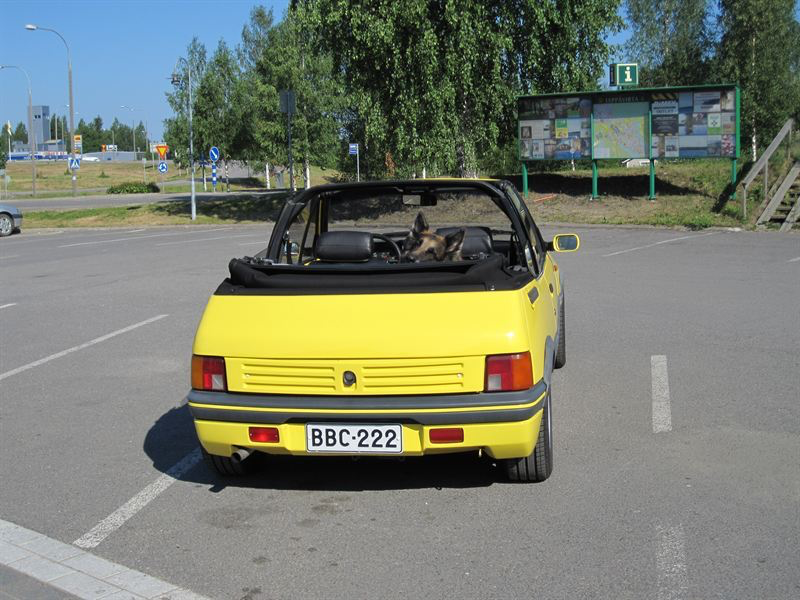 Keltainen Peugeot Cabriolet -avoauto parkkipaikalla