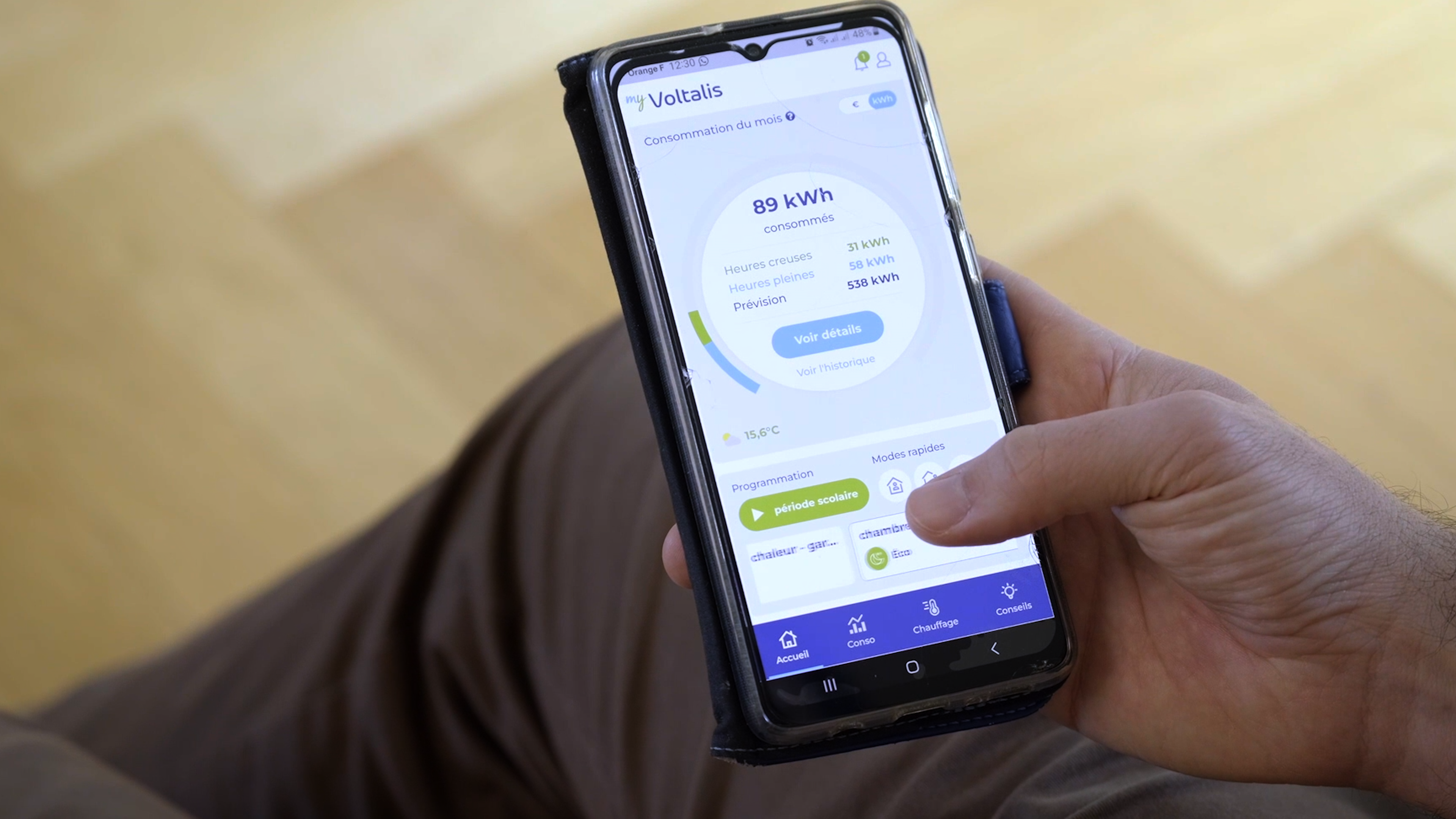 Persoon houdt een mobiel vast met voltalis app open