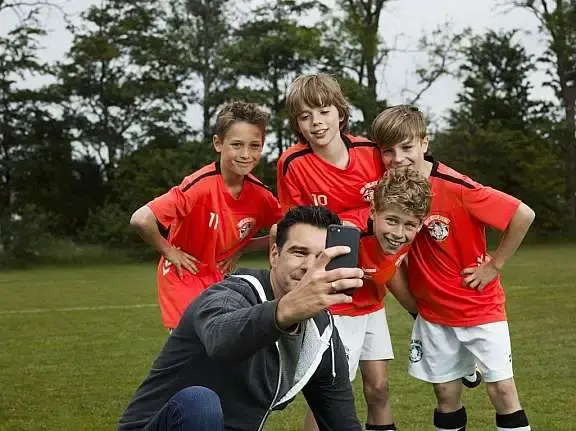 Man maakt selfie met enkele jonge sporters