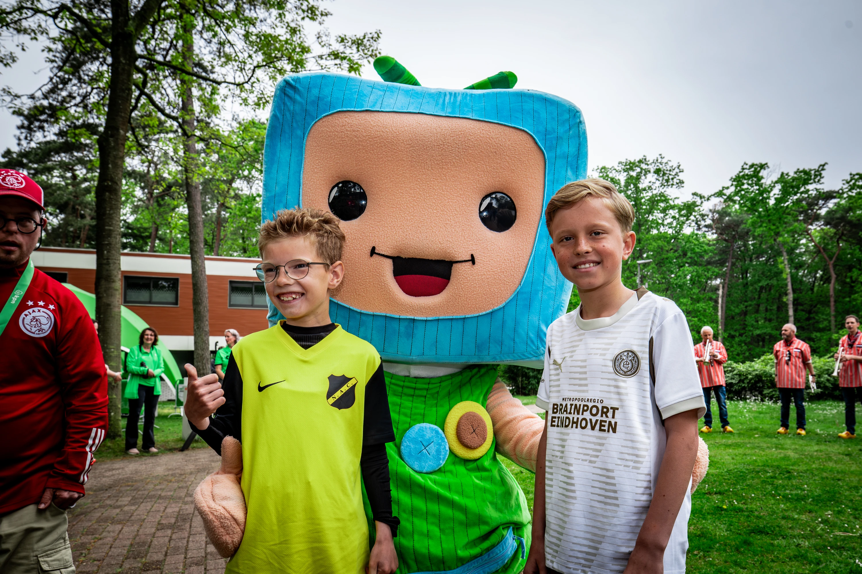 Twee jongens poseren met Maatje van KlasseContact voor de foto op KPN voetbalvriendendag