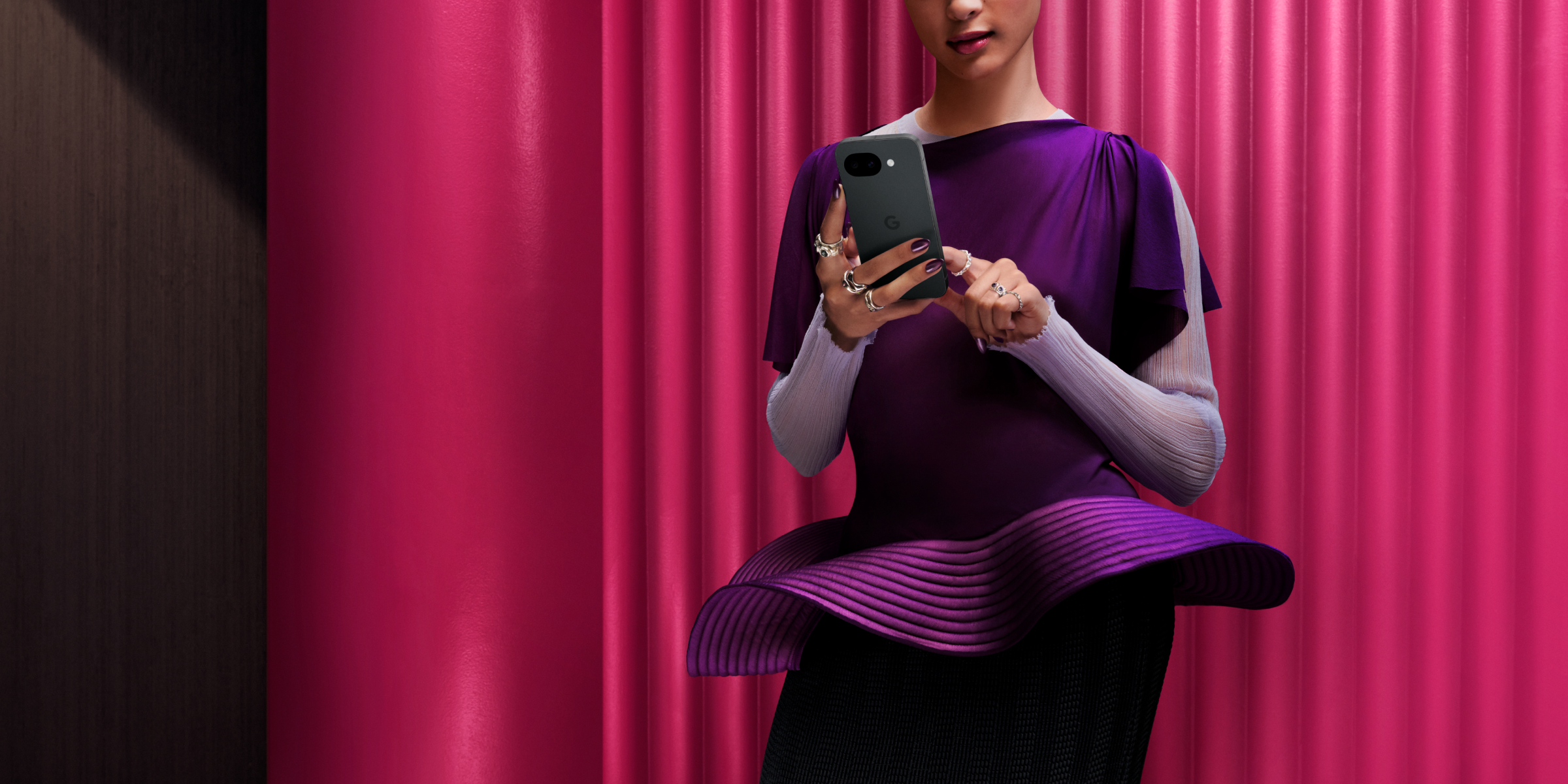 Vrouw in paarse jurk heeft Google Pixel 10a in haar hand