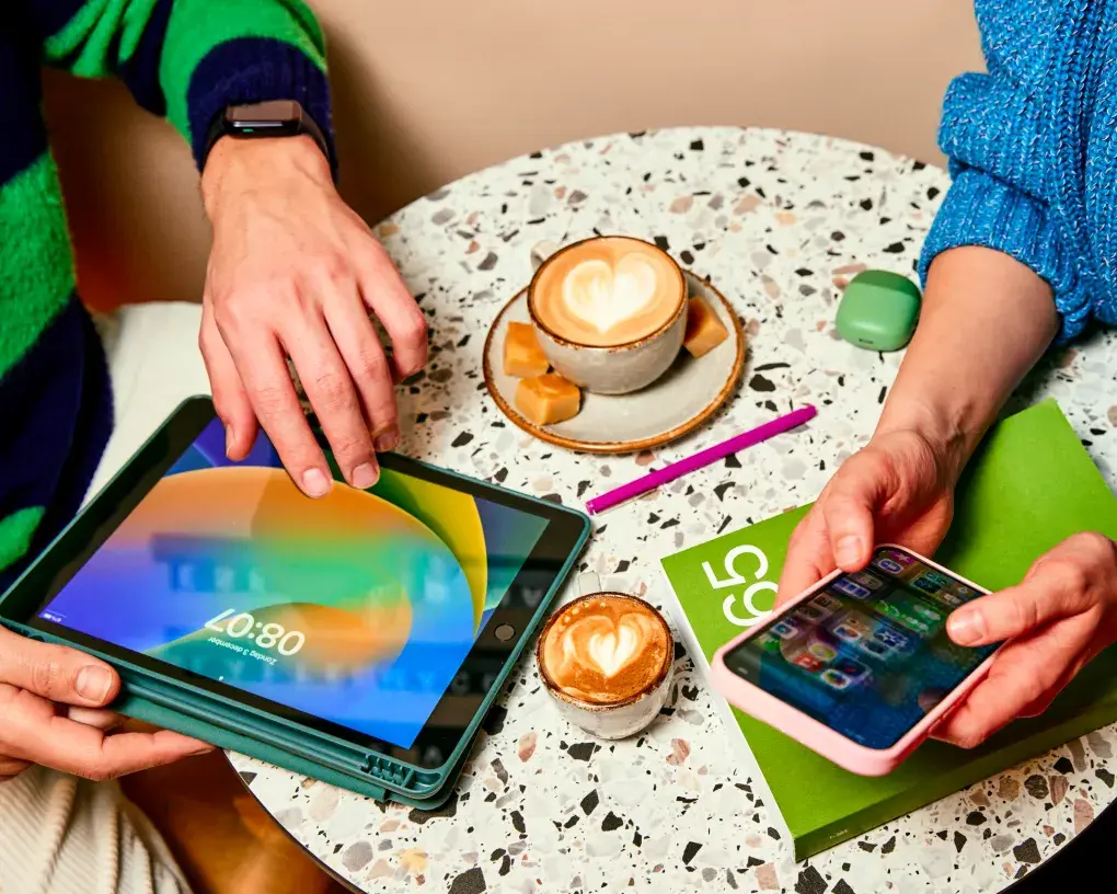 Mensen aan tafel met koffie en tablet en mobiel