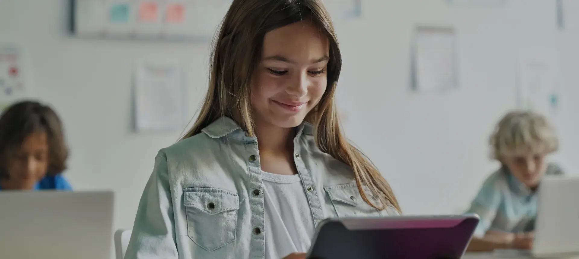 Meisje in de klas met een tablet voor zich