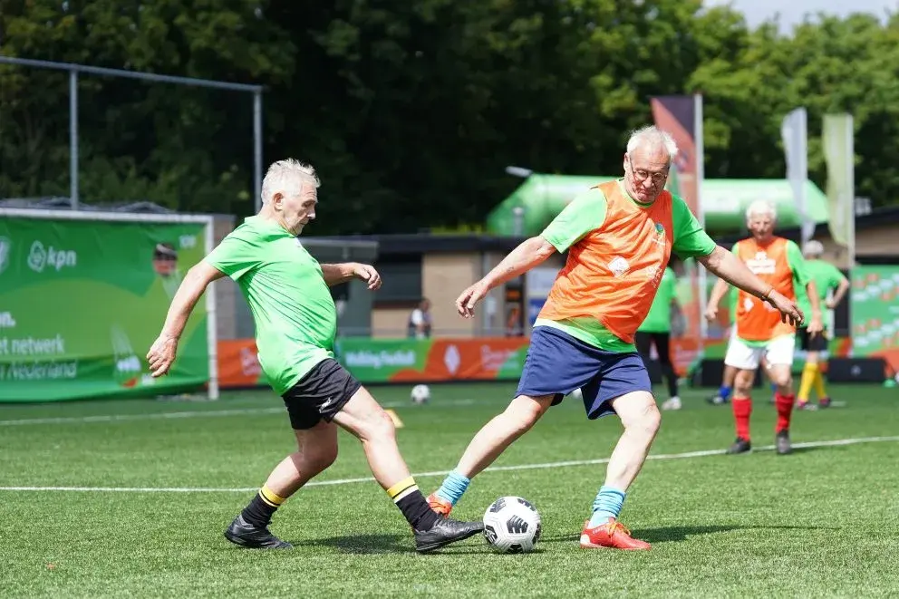 wedstrijd walking footbal, spelers proberen een bal te veroveren