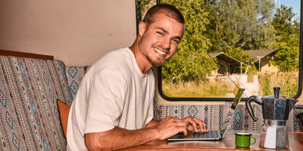 Man met laptop in zijn busje