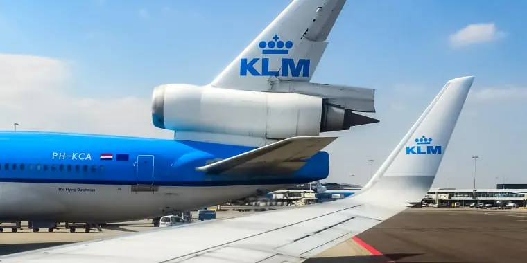 Afbeeldingen van de achterkant van een KLM-vliegtuig op een luchthaven.