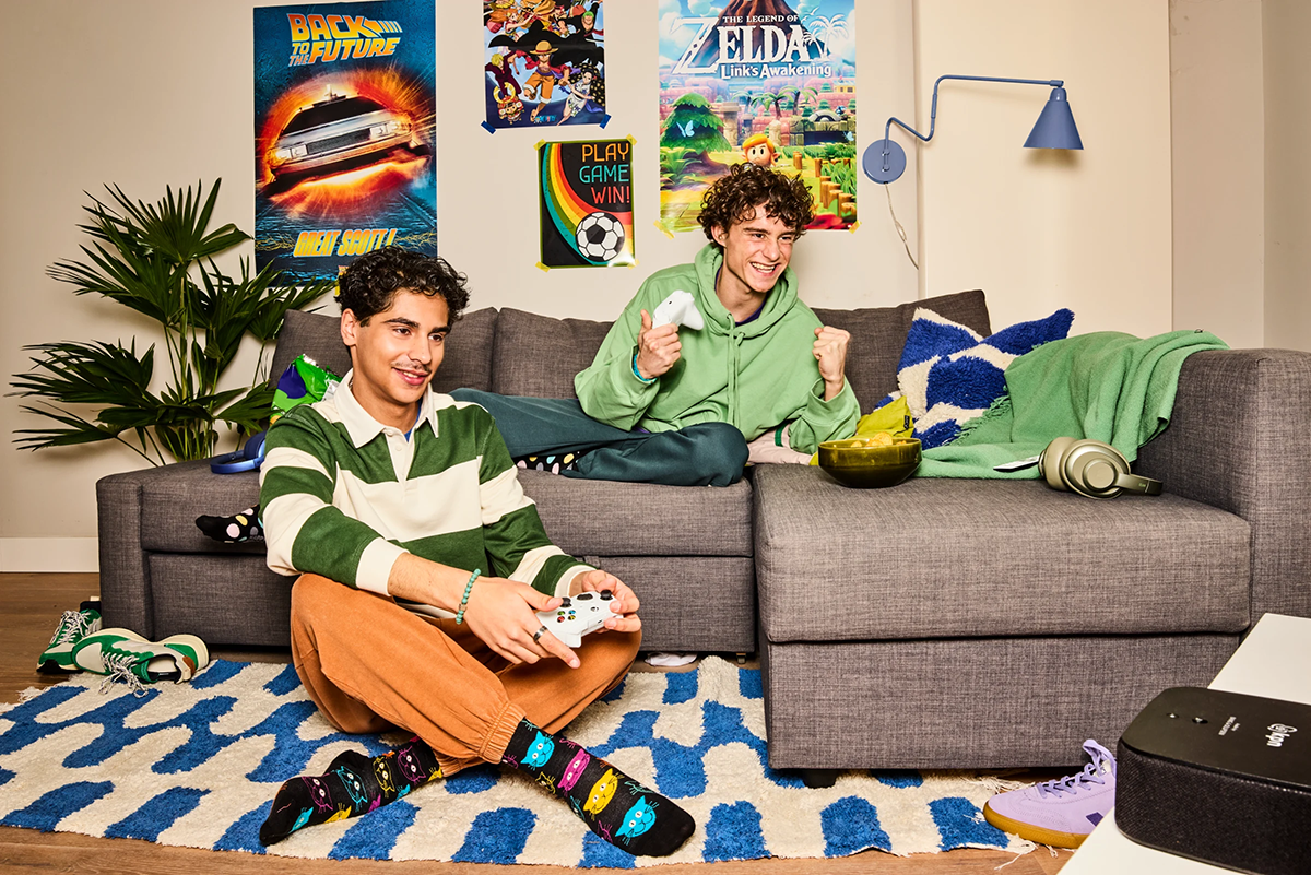 2 jongens zijn samen aan het gamen op de bank