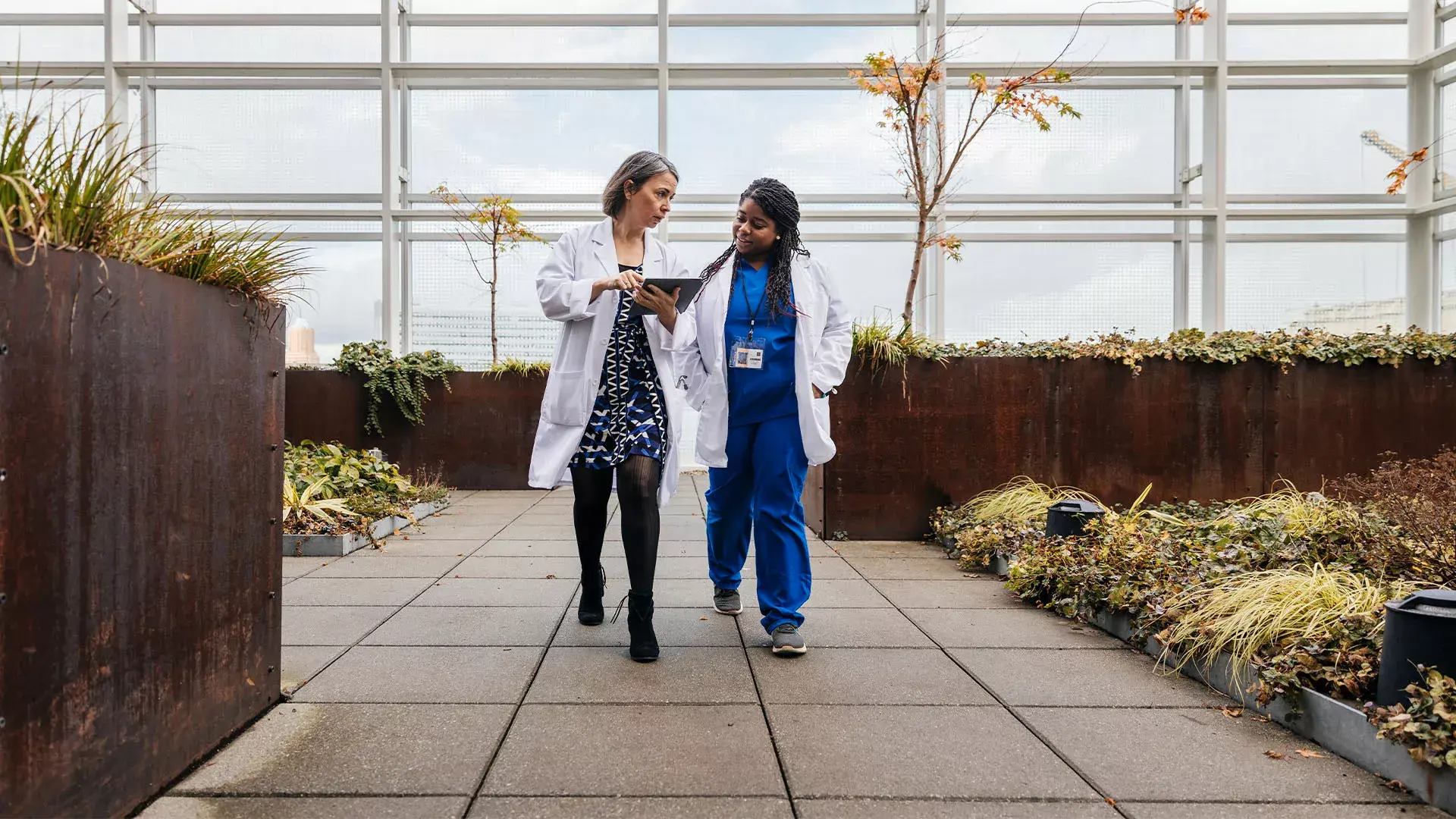 Twee vrouwelijke artsen wandelen met rapport buiten