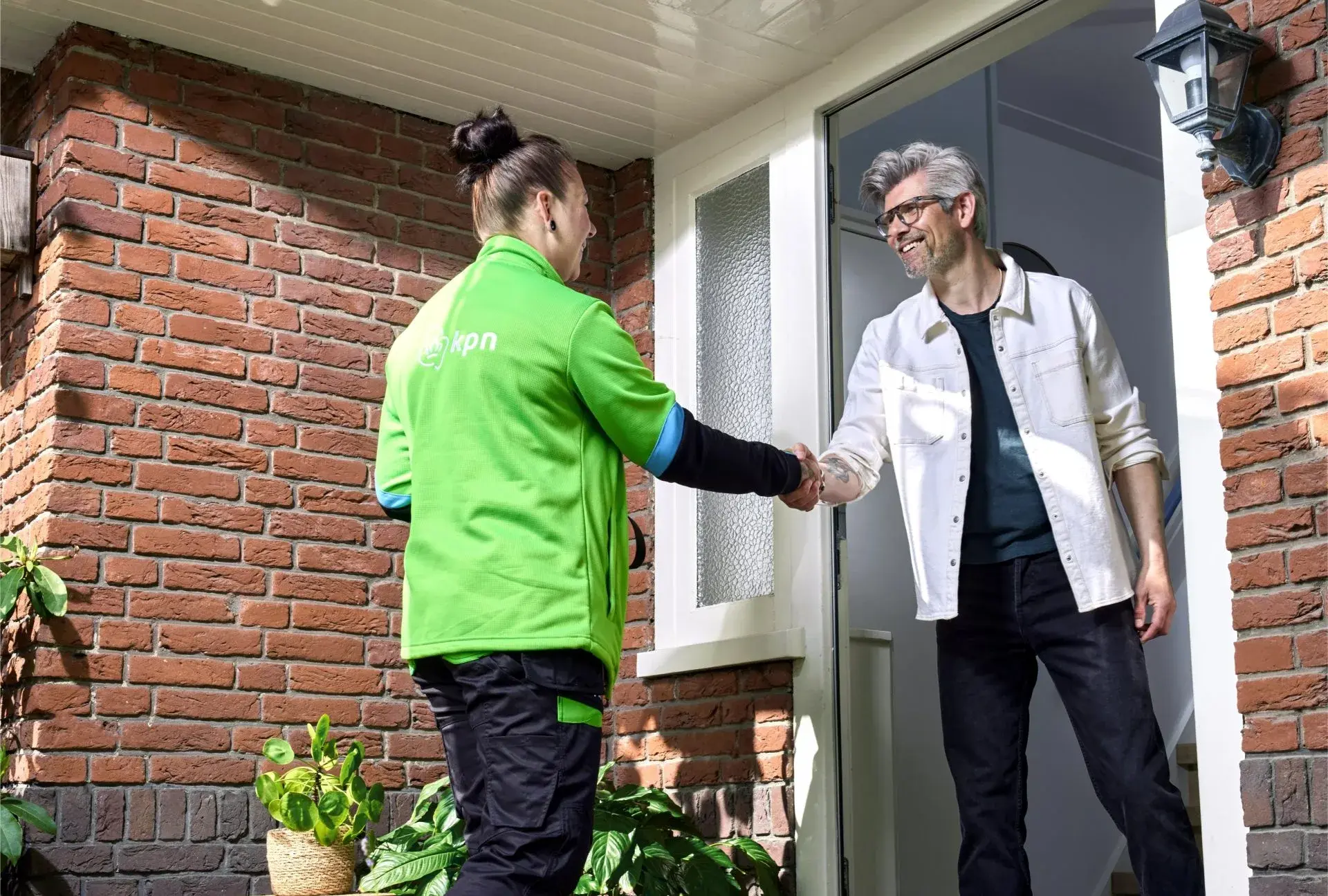 Kpn monteur bij klant aan de deur en schudden handen