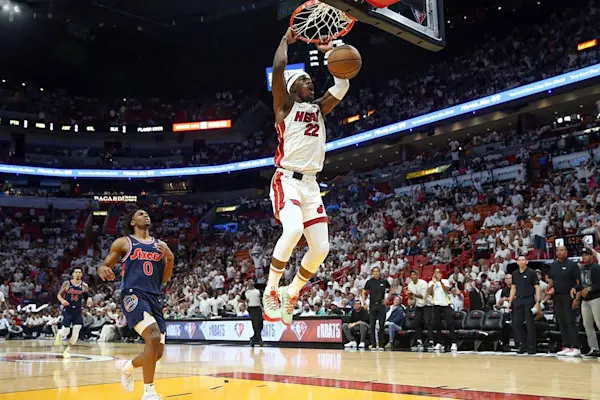 Een basketballer dunkt de bal door de basket tijdens een NBA-wedstrijd.