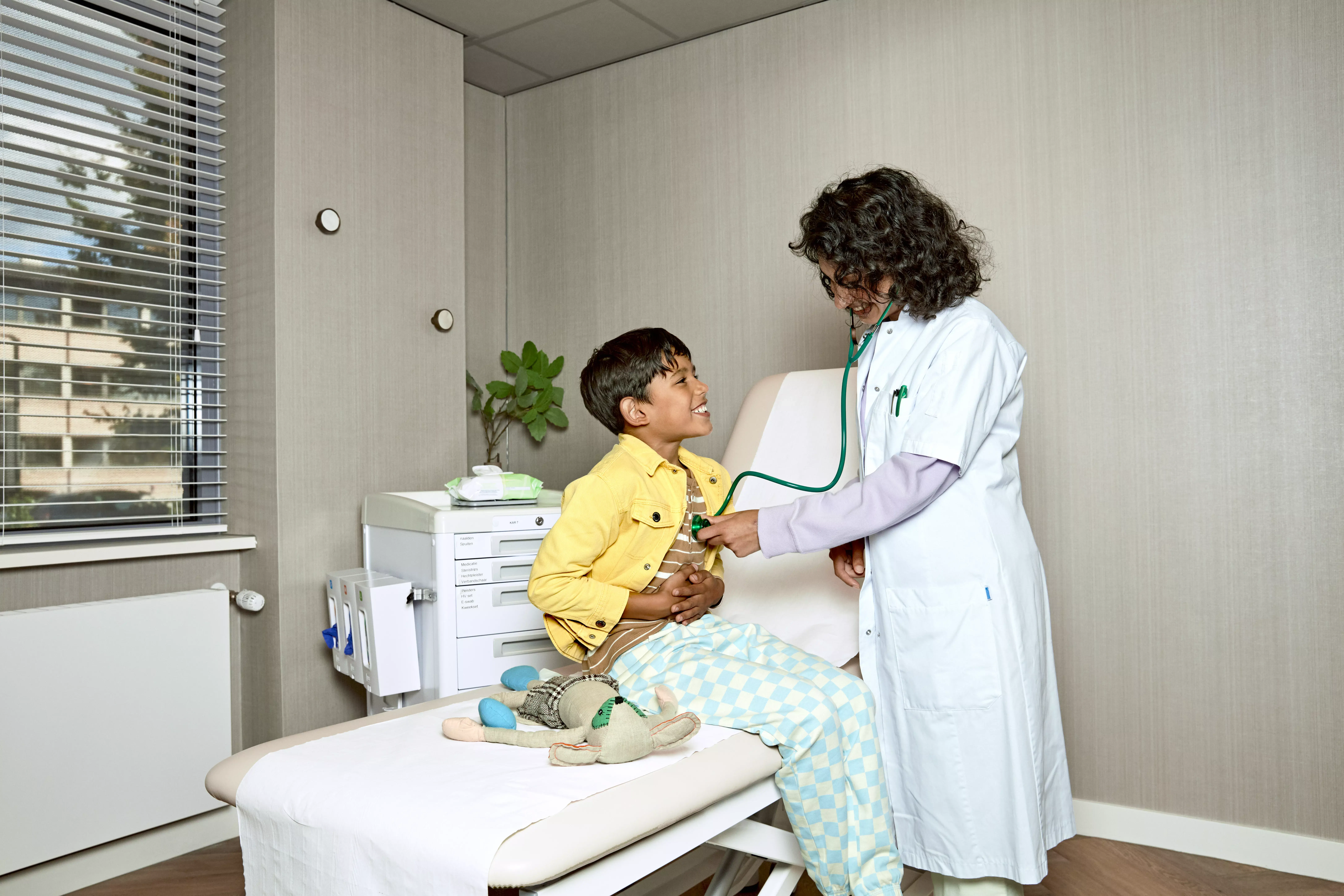Vrouwelijke arts controleert jongetje met stethoscoop