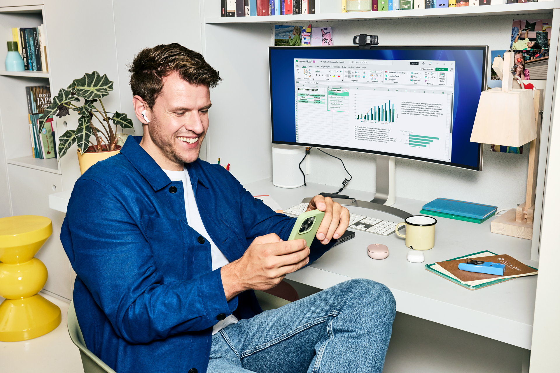 Man die thuiswerkt met mobiel in de hand