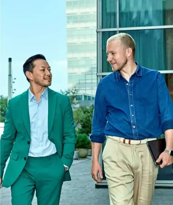 twee mannen lopen op straat en overleegen al lopende met elkaar