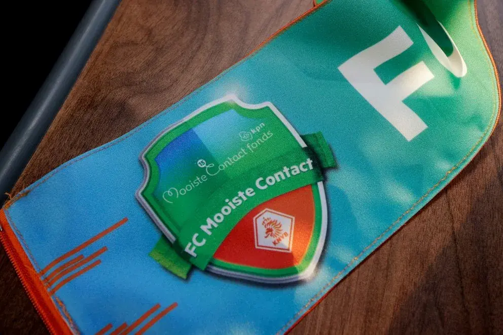 Deel vande sjaal wordt getoond met het logo van FC mooiste contact