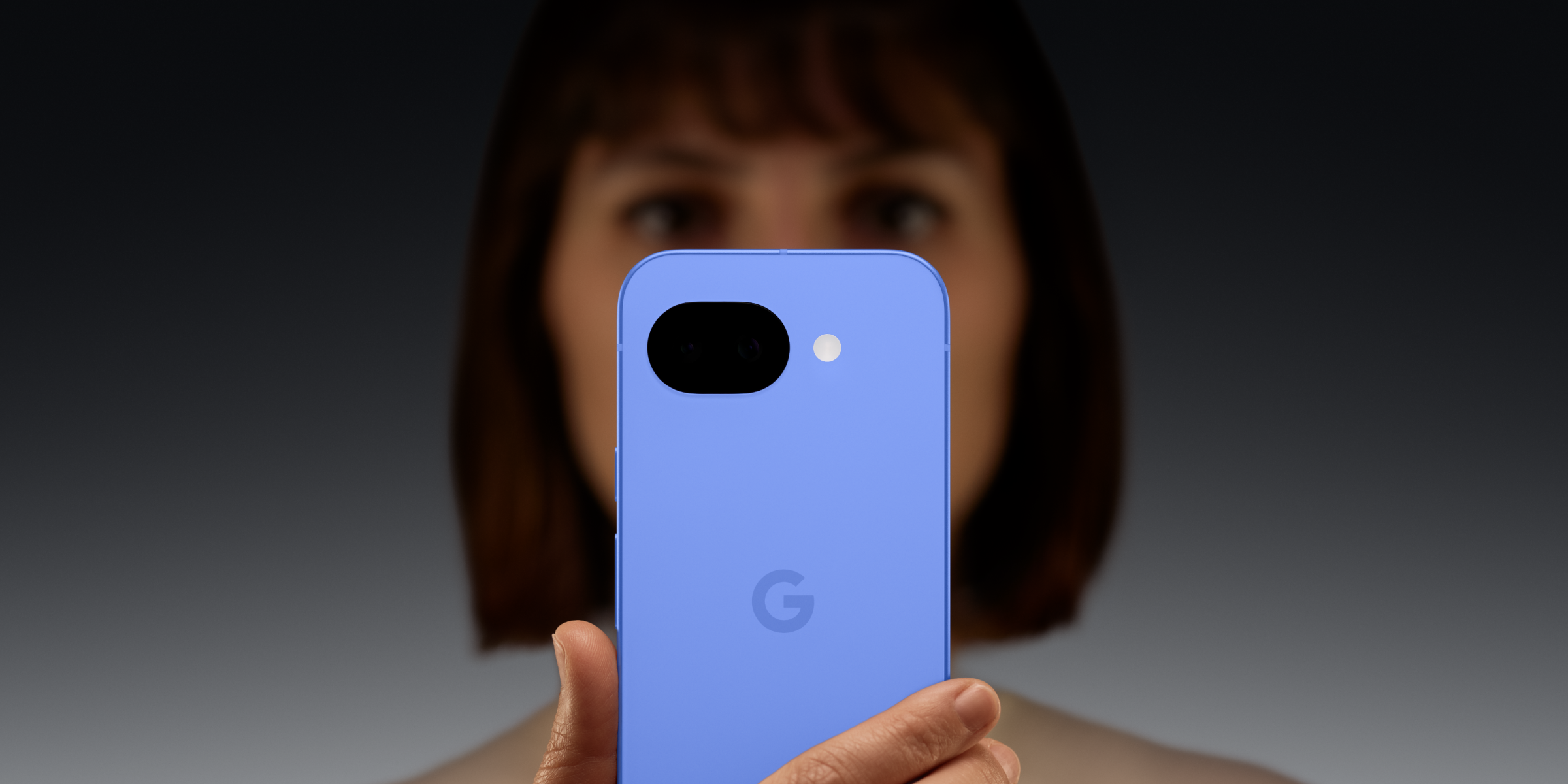 Vrouw laat achterkant Google Pixel 10a zien