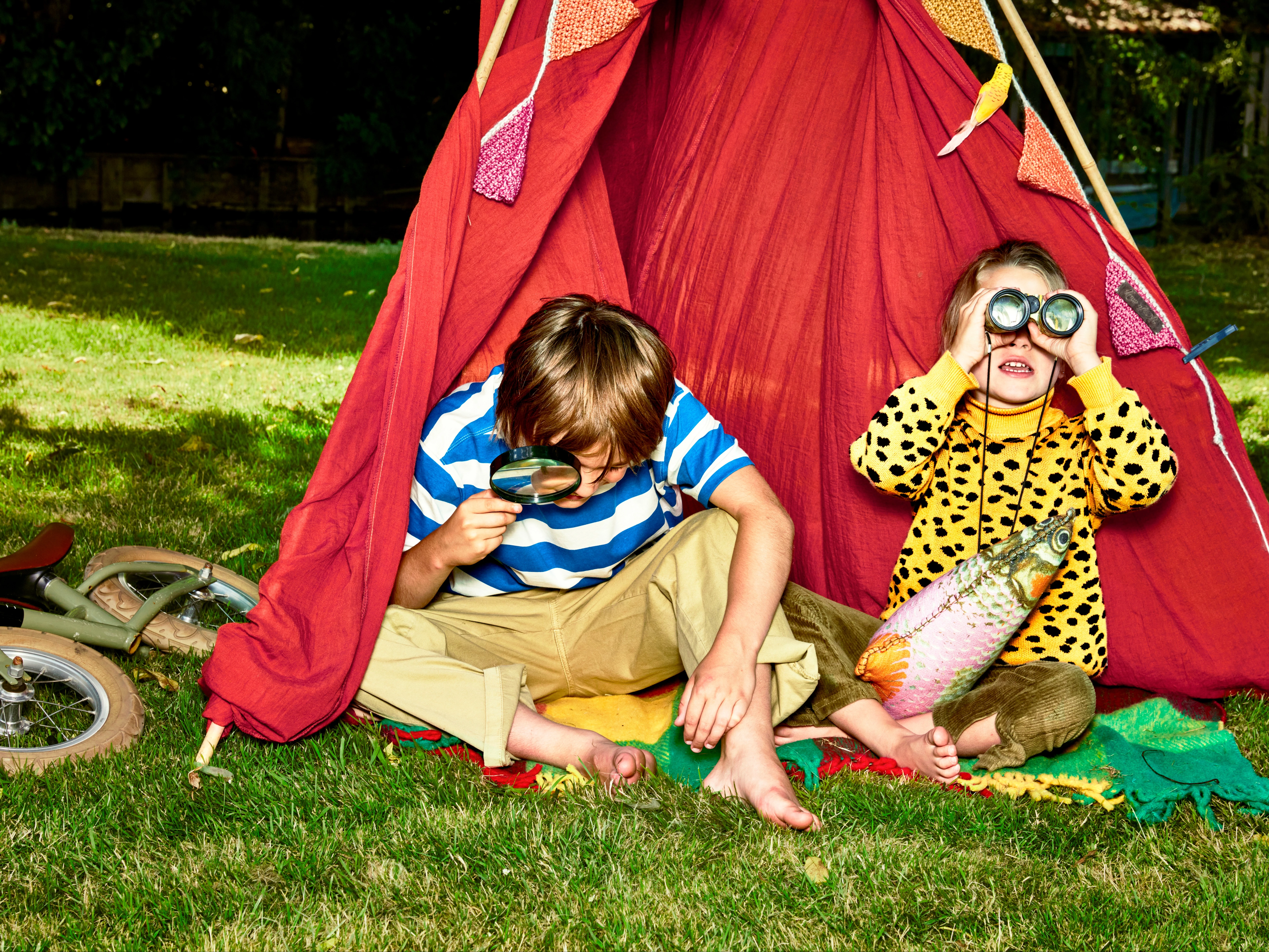 twee kinderen in een tent met vergrootglas en verrekijker