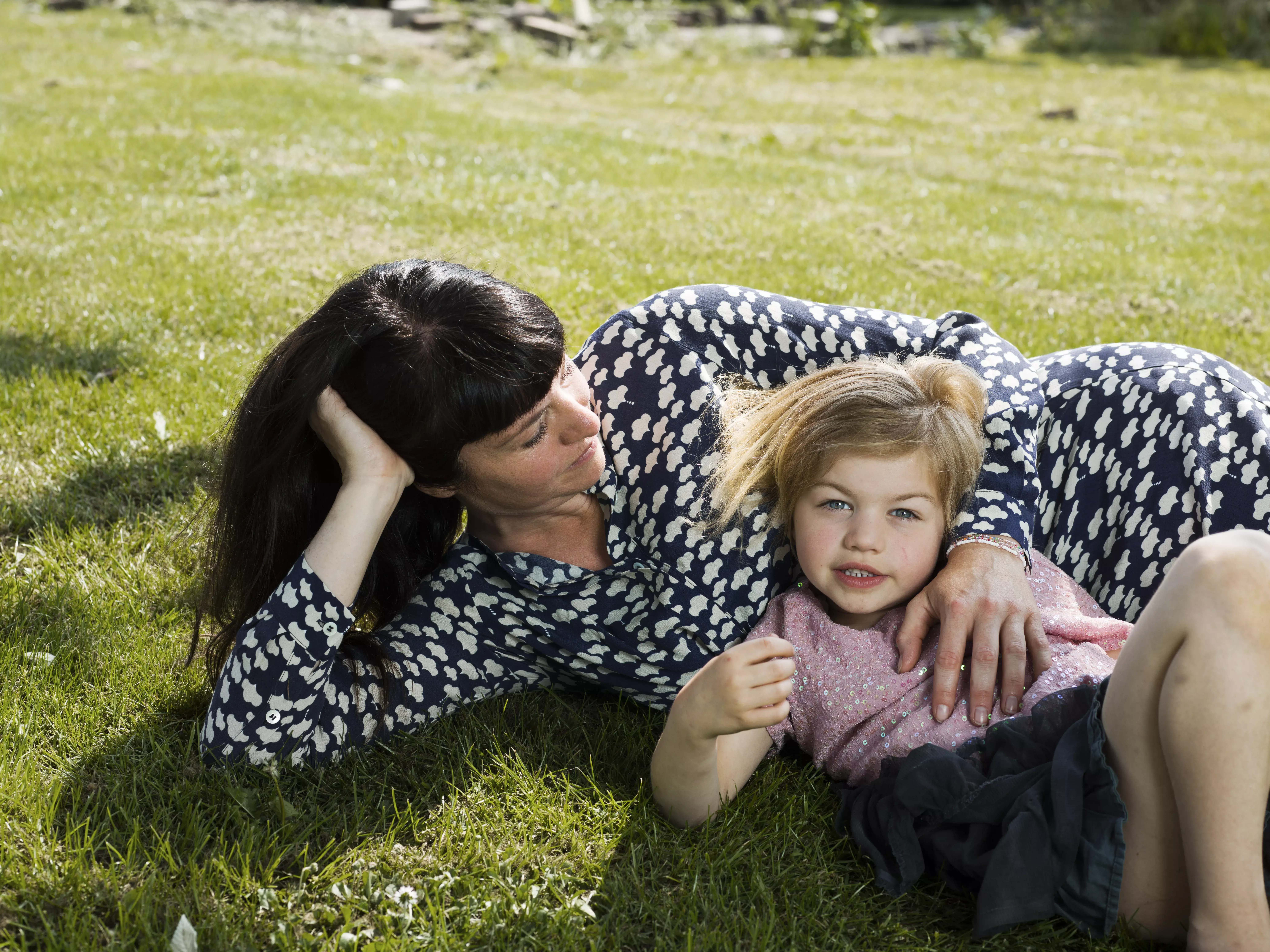 vrouw met kind liggend in het gras
