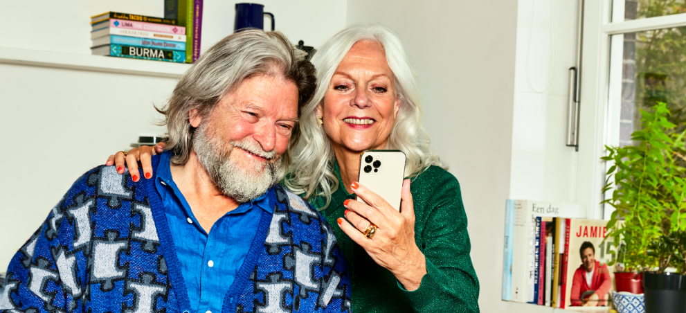 Man zit op zijn telefoon en laptop tegelijk