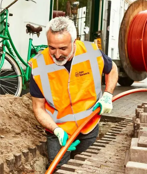 Monteur bezig met uitrollen glasvezelkabel in de grond