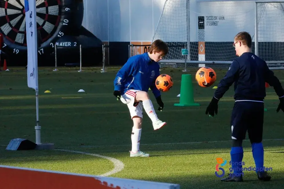Twee jongens zijn bal aan het hoog houden tijdens de eerste KPN voetbalvriendendag