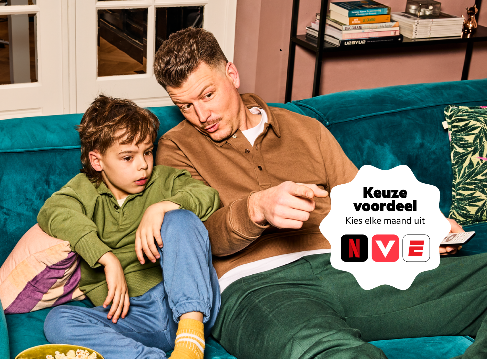 Vader en zoon kijken tv op de bank. Met Combivoordeel kies je uit Netflix, Videoland of ESPN Compleet.