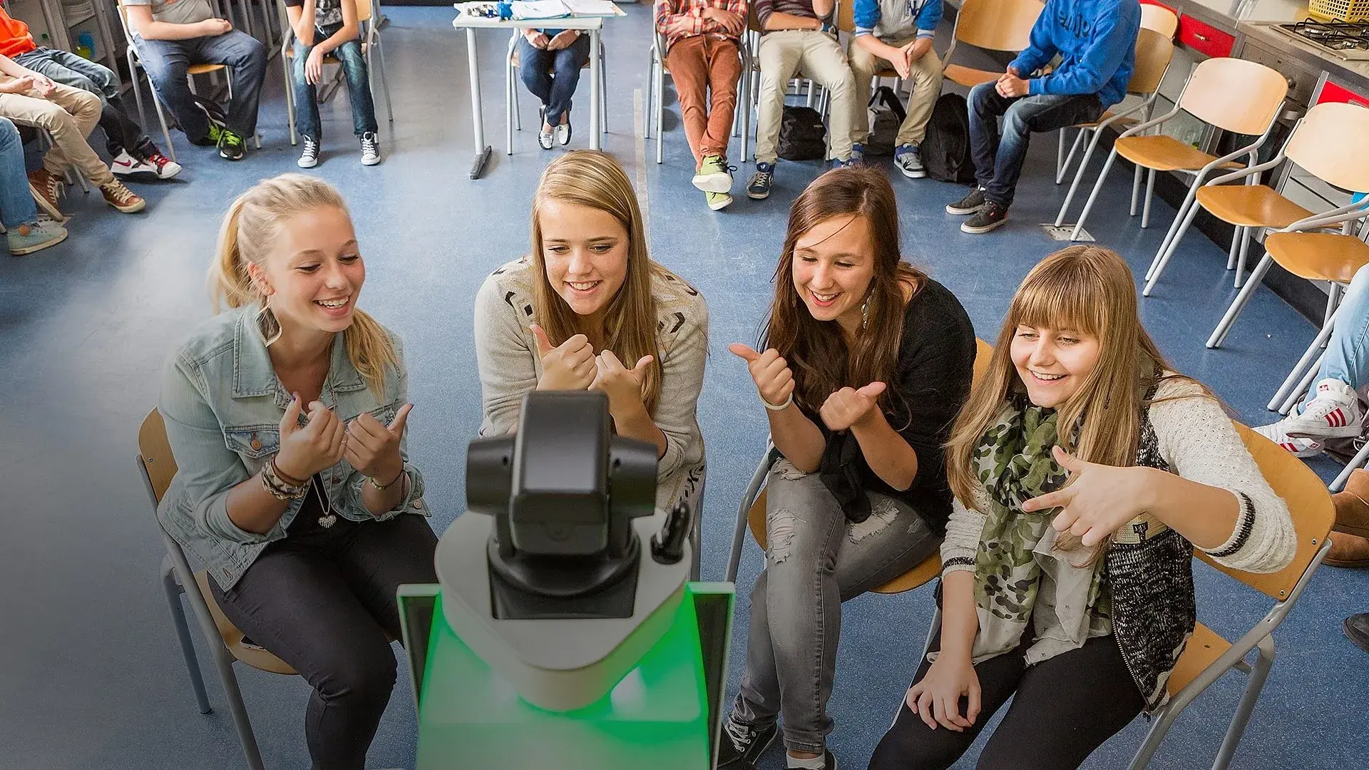 Schoolkinderen zitten voorde neuwe Klasgenoot te praten met hun klasgenoot die ziek thuis zit