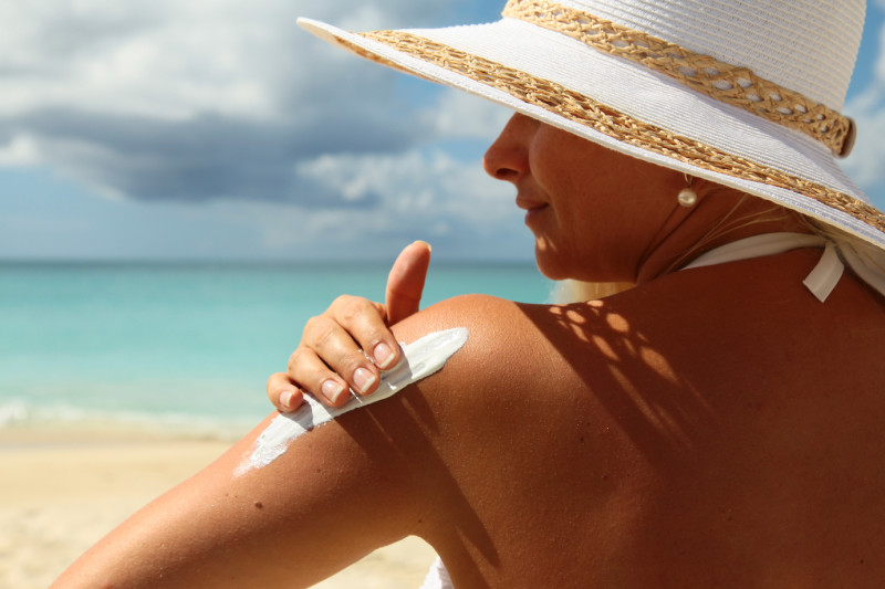 woman-applying-suntan-lotion-at-the-beach
