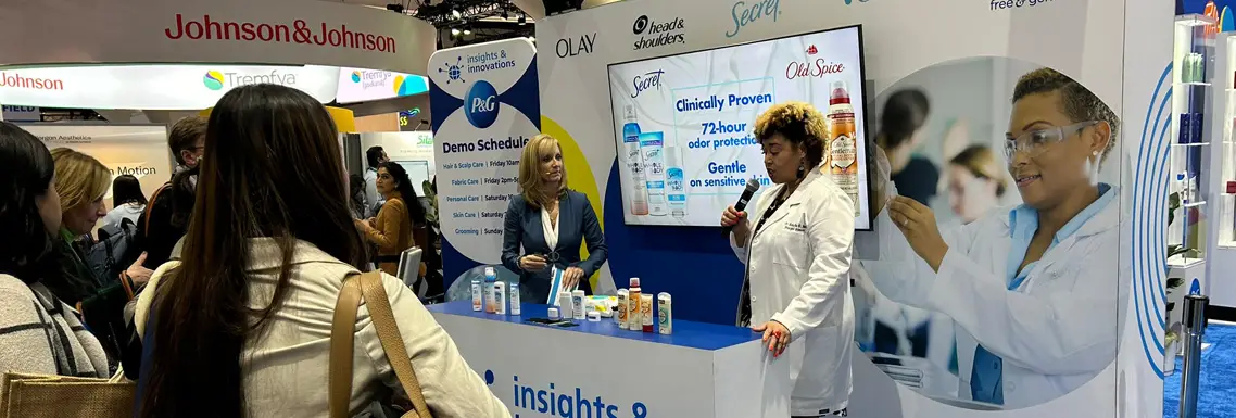 people standing and listening to a presentation in front of an insights & innovations booth
