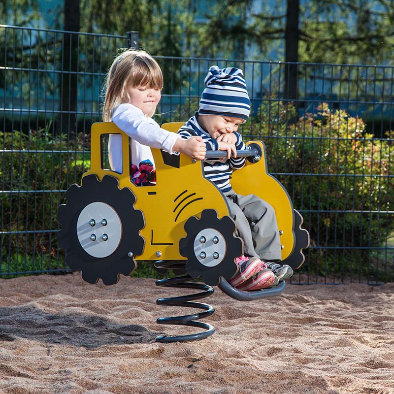 Två barn på ett gungdjur i form av en traktor