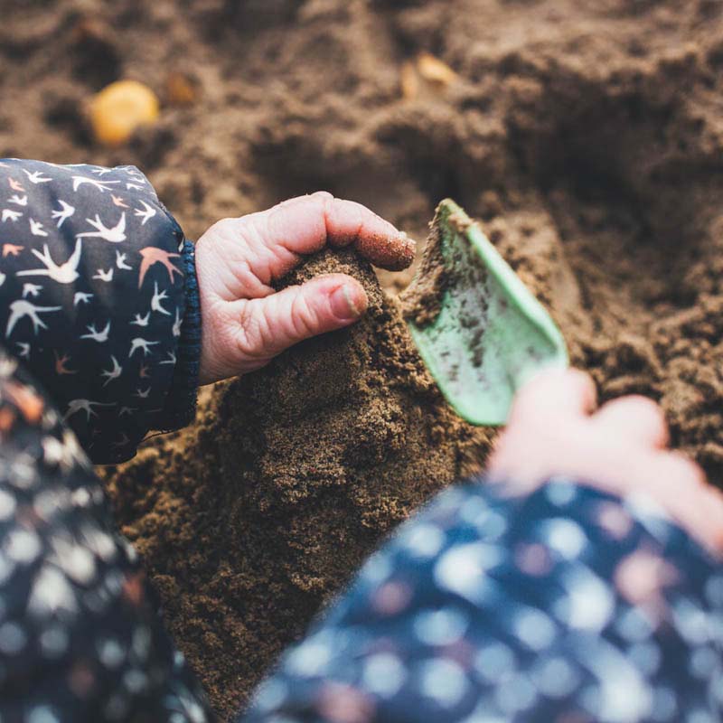 Inkluderende lekeplass, Lerum, Sverige Jente leker med sand