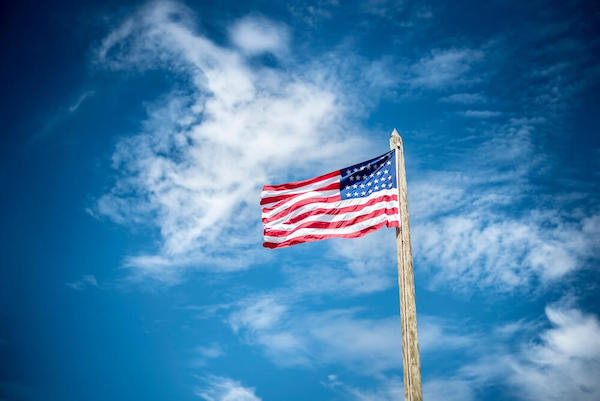 American Flag An American flag with a blue sky background.