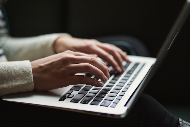 Hands typing on a laptop A person typing on a laptop