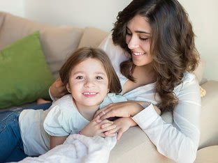 Une mère et sa fille jouent sur un divan