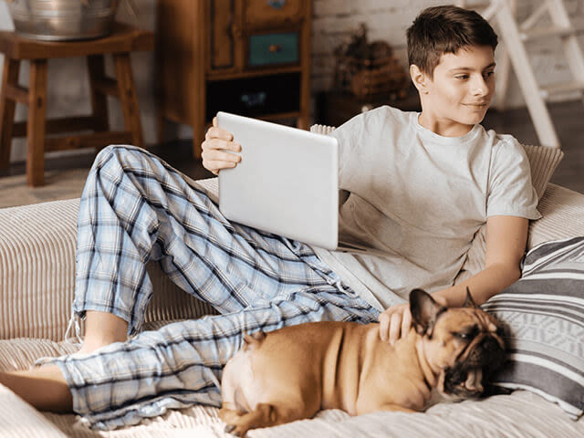 Garçon installé sur le canapé avec son chien