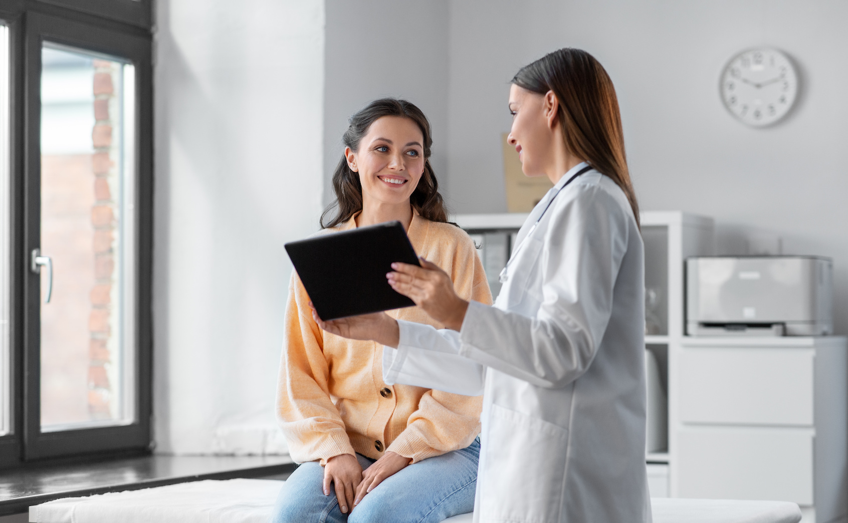 A woman talking with her doctor about health, fitness, and preventive care.