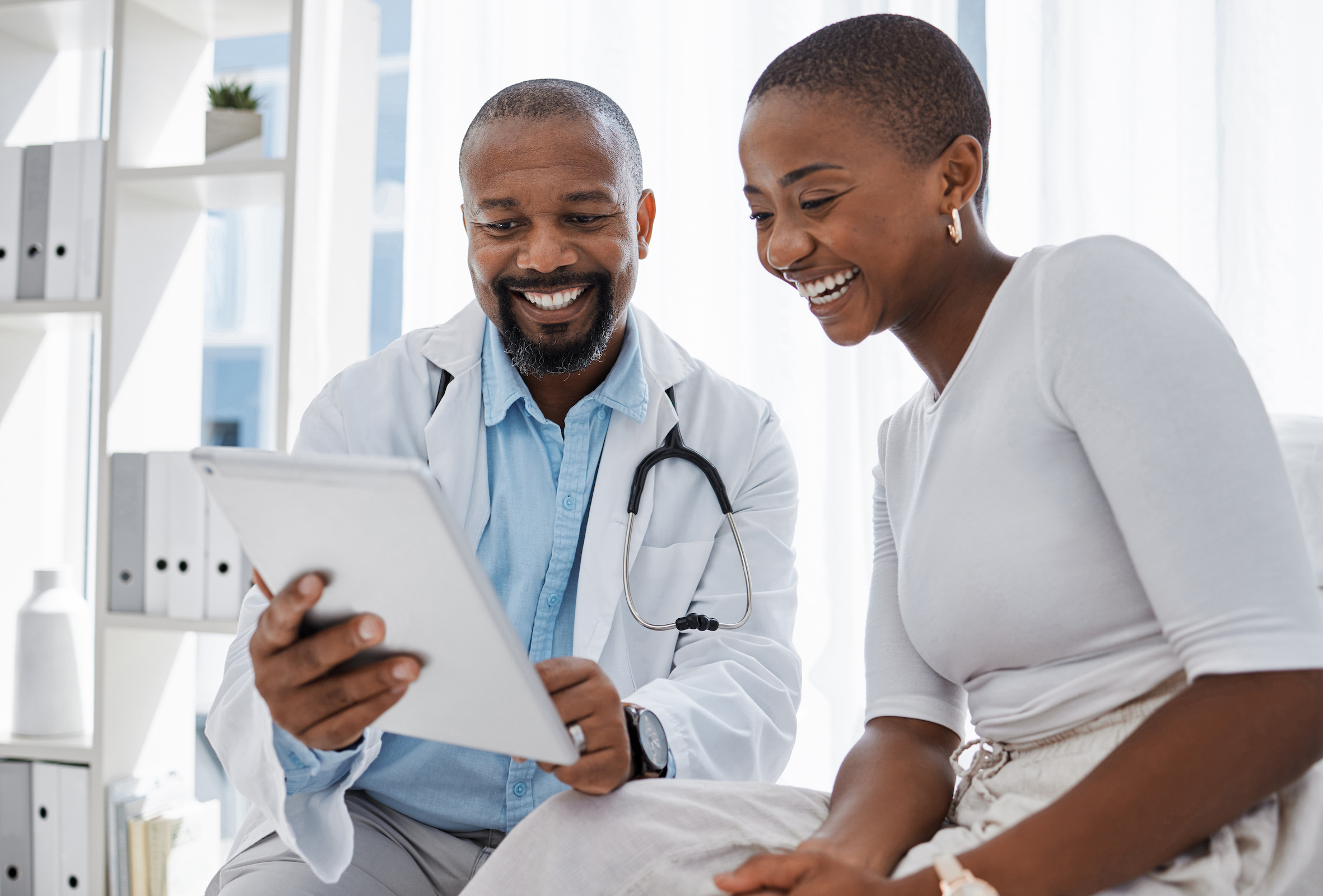 A smiling cash pay patient engaged in a positive conversation about her healthcare with her doctor.