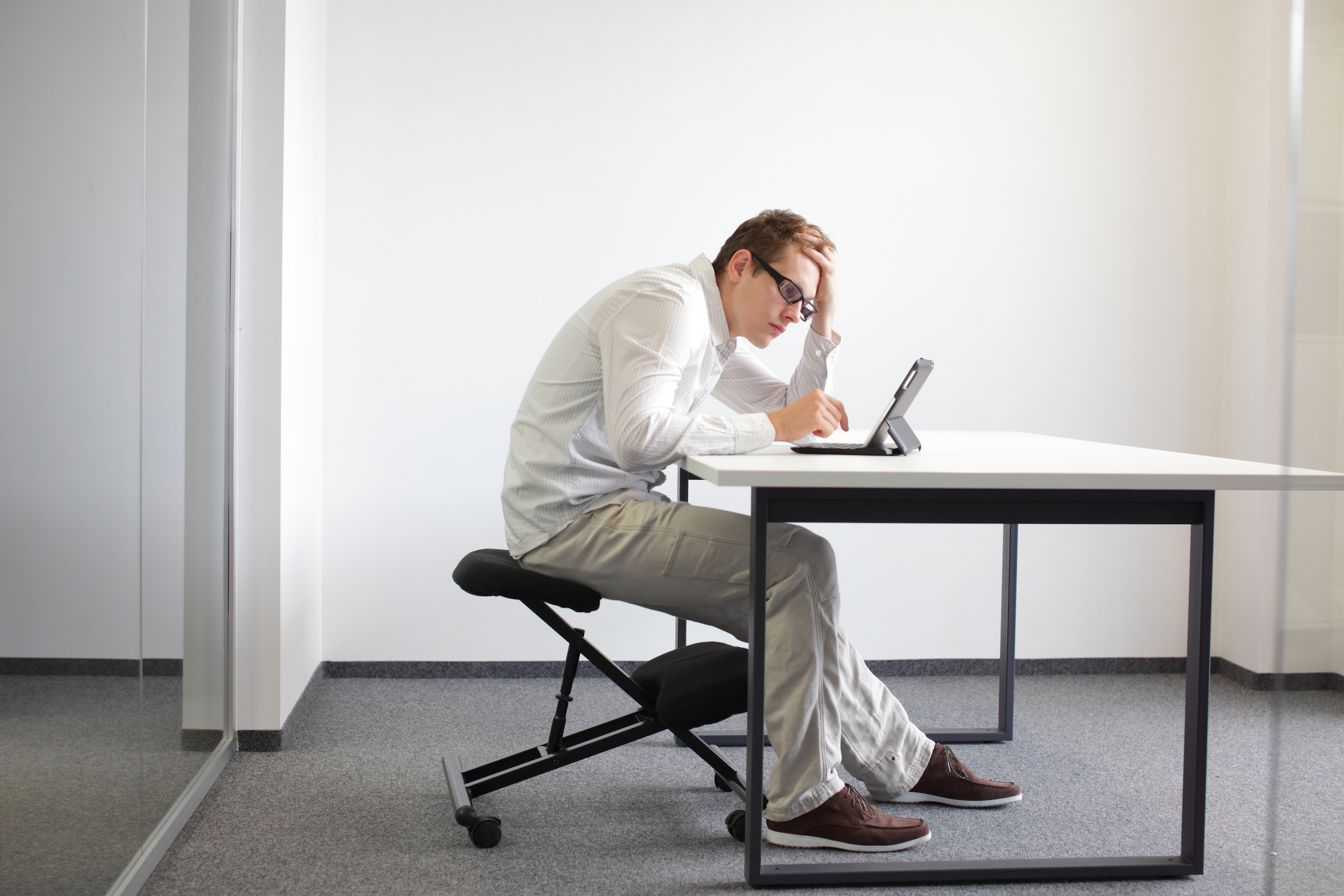 Man slouching over desk with poor posture.
