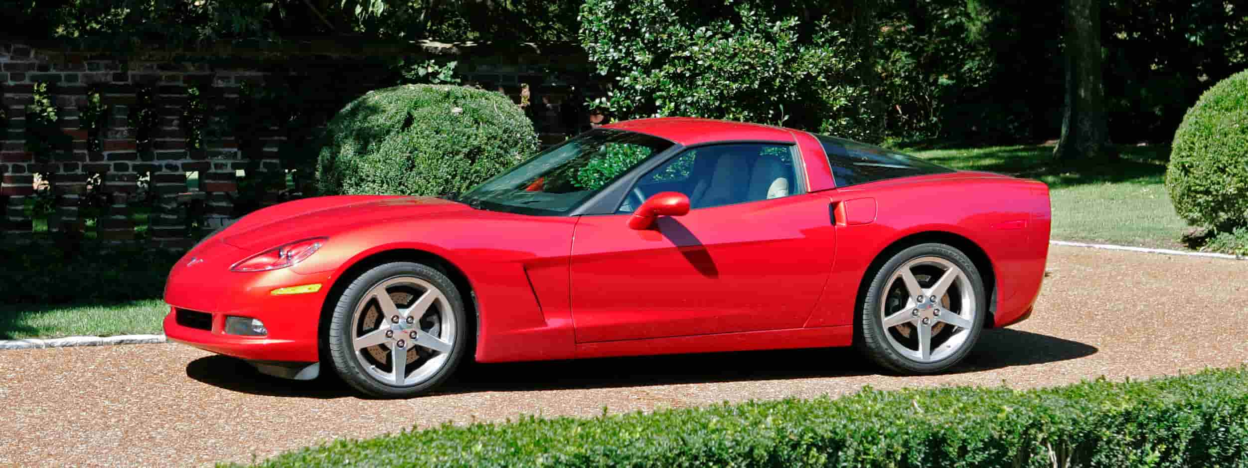 A red Chevy Corvette sits in a driveway.